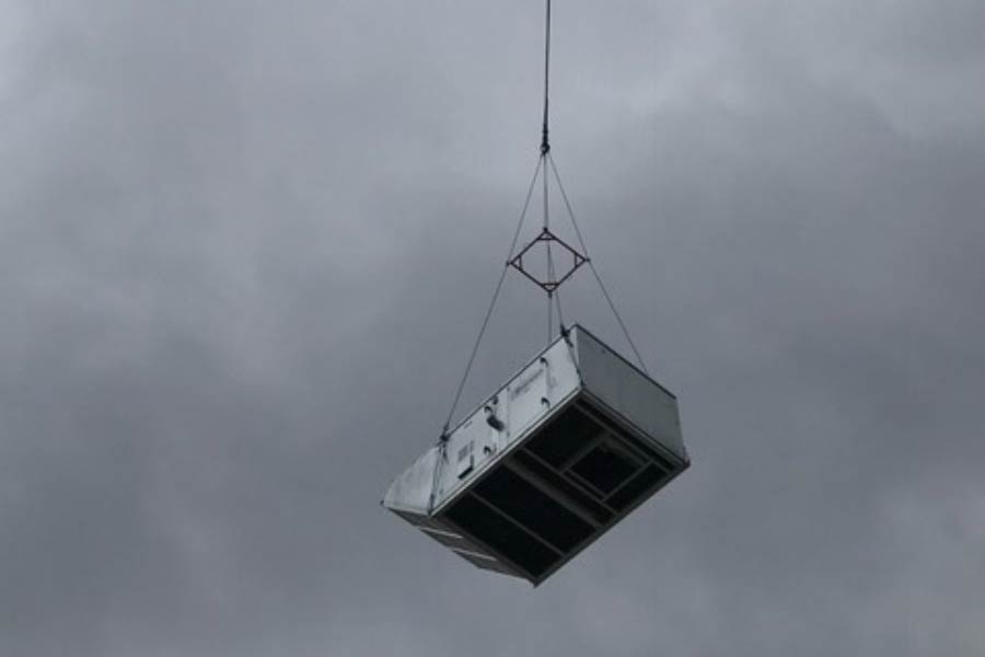 Crane lifting HVAC system